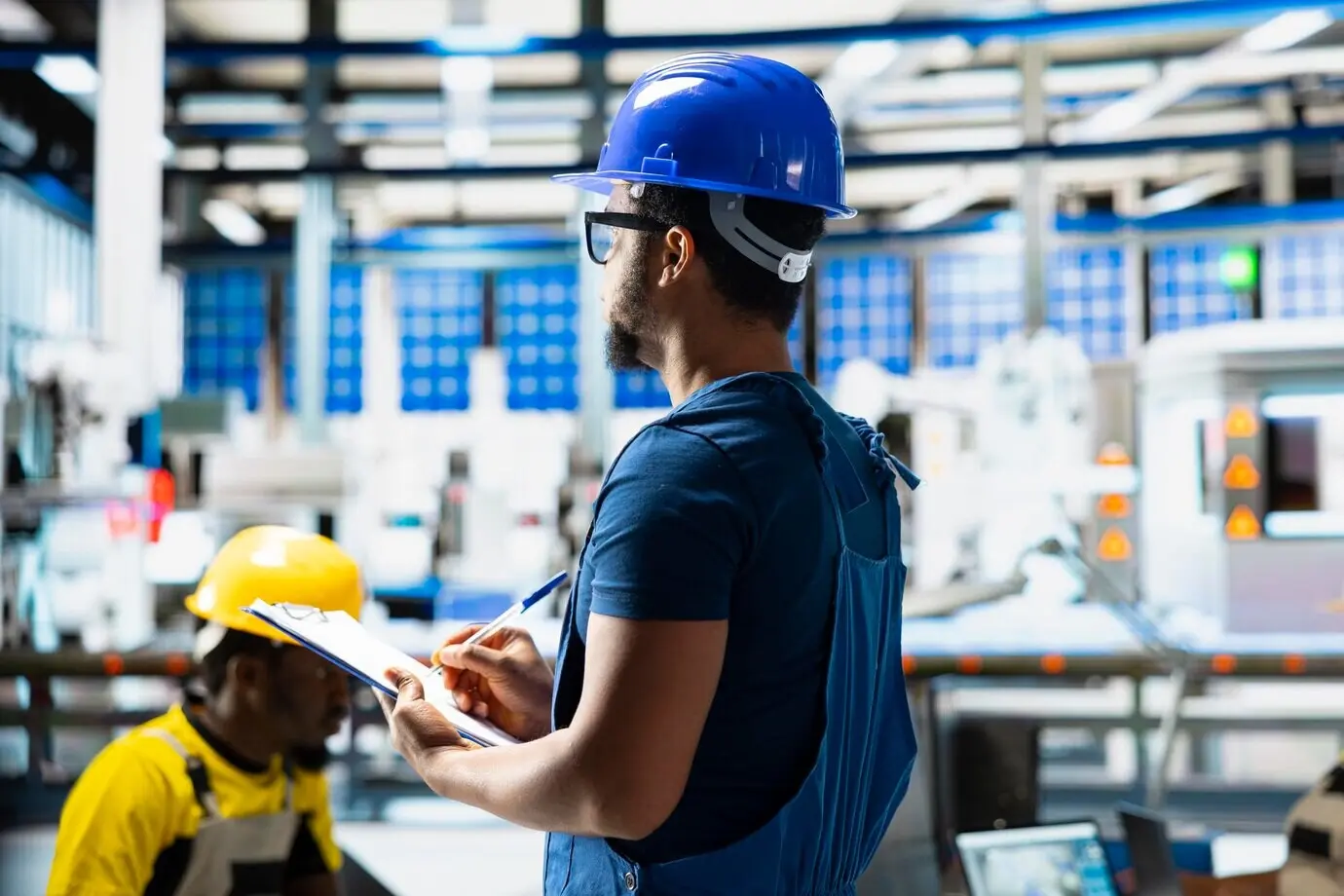 Руководитель-афроамериканец оценивает показатели возобновляемой энергии на заводе.